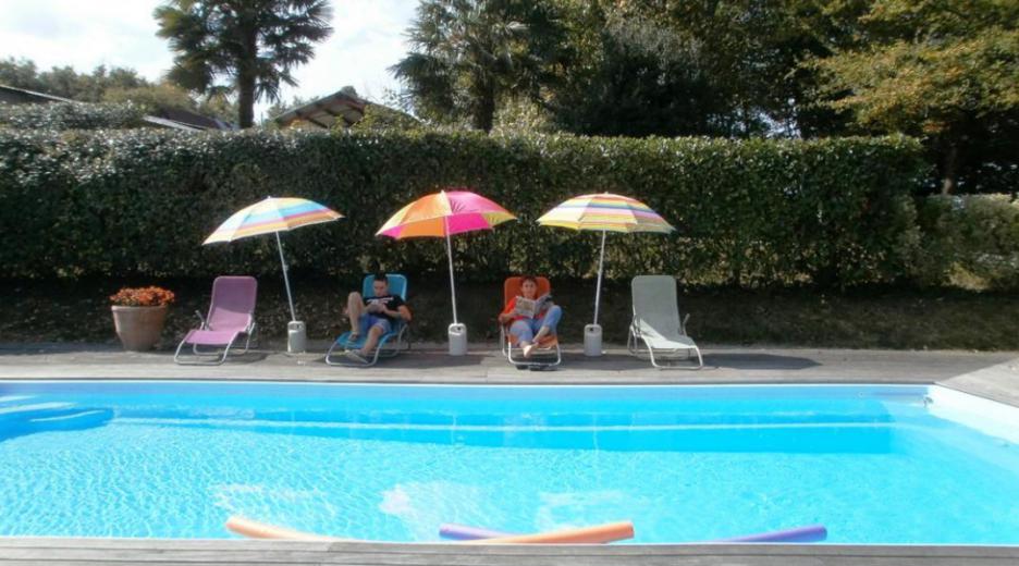 Espace détente au bord de la piscine maison Canterou Monein